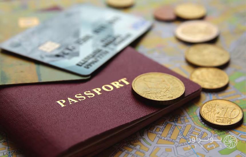 تصویری از بخشی از یک پاسپورت، چند سکه و یک کارت اعتباری